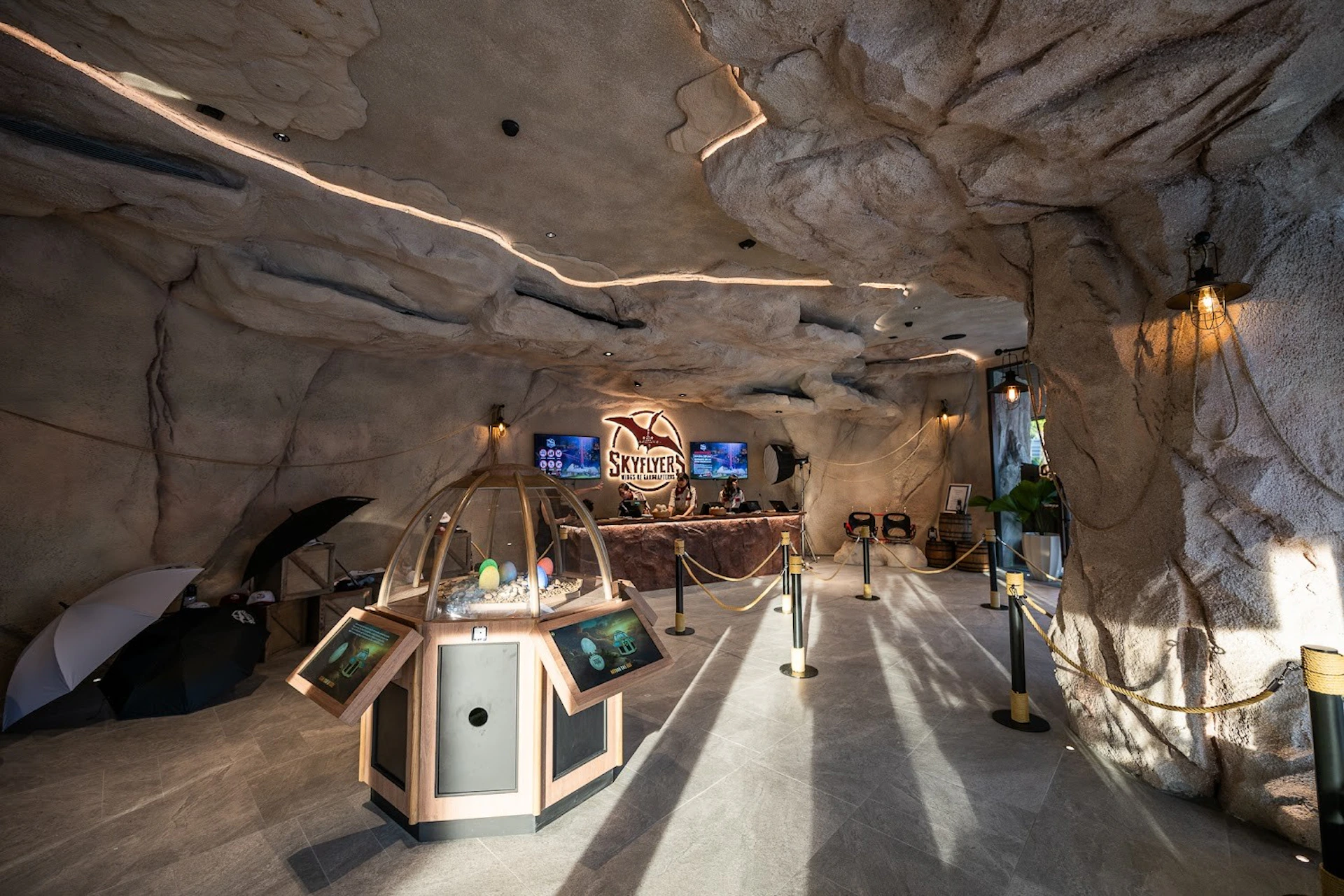 A cave-like interior with a reception desk labeled "SkyFlyer," interactive displays, and decorative lighting.