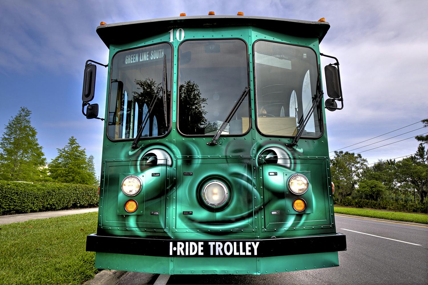 Zelený trolejbus s označením „I-RIDE TROLLEY“ na přední straně, s textem „Green Line South“ zobrazeným výše.