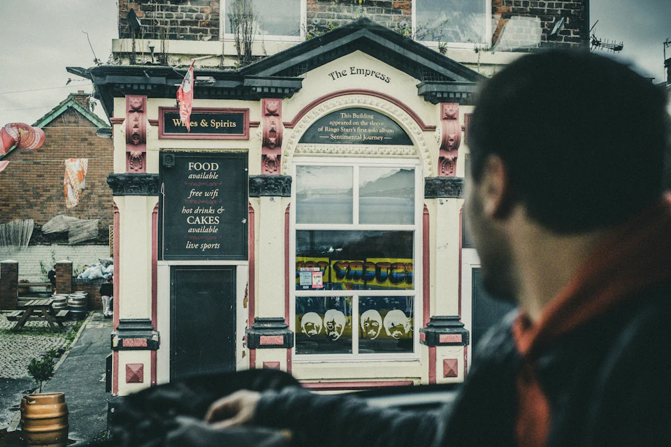 A person looks at The Empress pub facade, which offers food, free WiFi, hot drinks, cakes, and live sports.