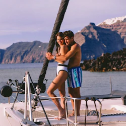 Couple on board a catamaran, next to the volcano.