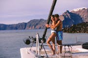 Couple on board a catamaran, next to the volcano.