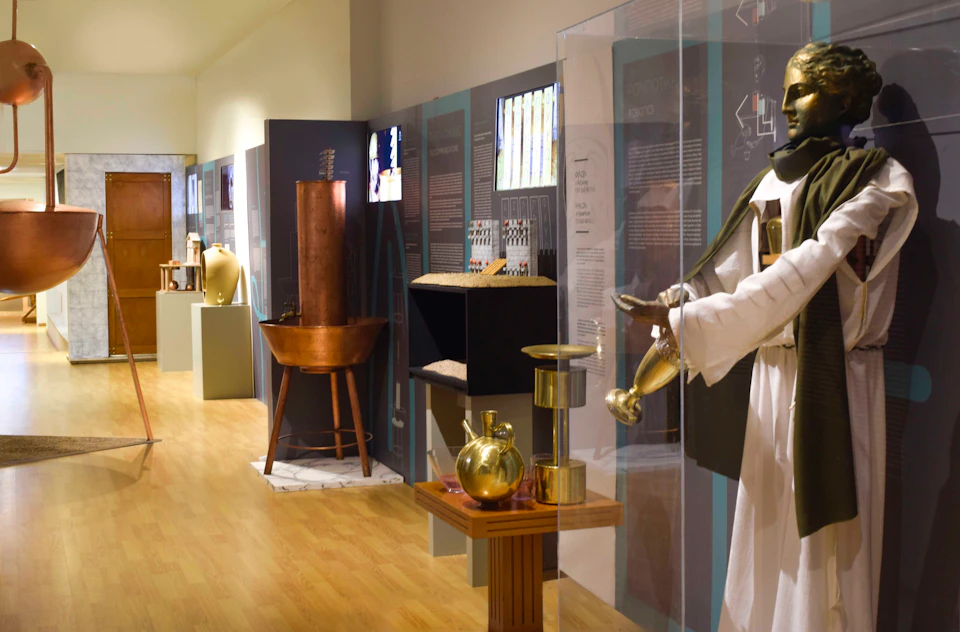 Modern museum exhibit on ancient science and technology, showcasing artifacts, replicas, and informative displays with text.