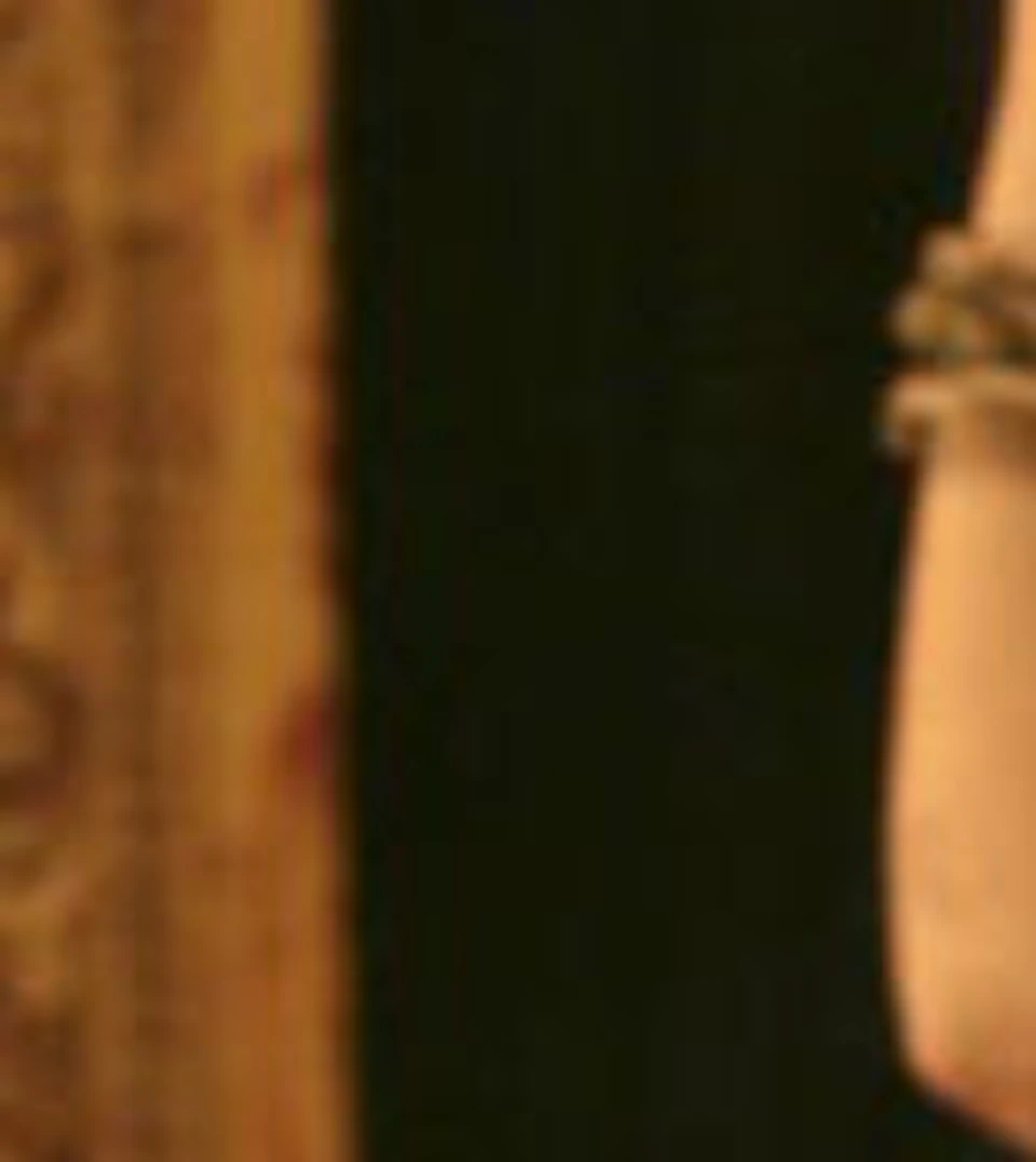 Two dancers in traditional attire perform a classical dance, with ornate headdresses and intricate costumes, in a dimly lit setting.