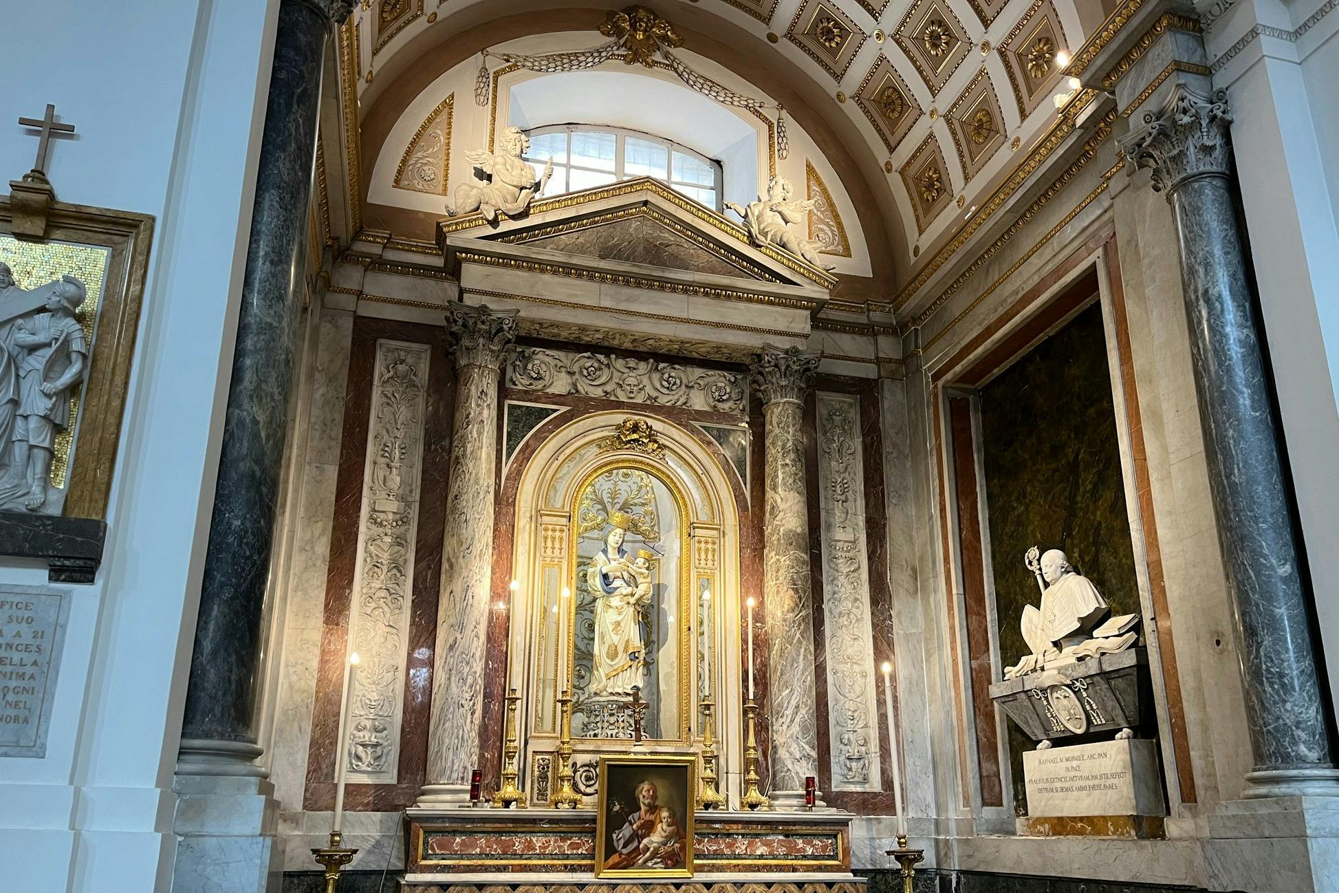 촛불이 달린 화려한 교회 제단, 중앙에 있는 성인의 동상, 아래 그림, 디테일한 벽 조각. 대리석 기둥이 측면을 장식합니다.