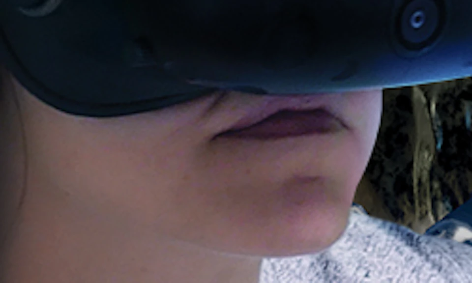 Two people wearing virtual reality headsets, holding VR controllers, simulating a space scene with stars and a lunar module backdrop.