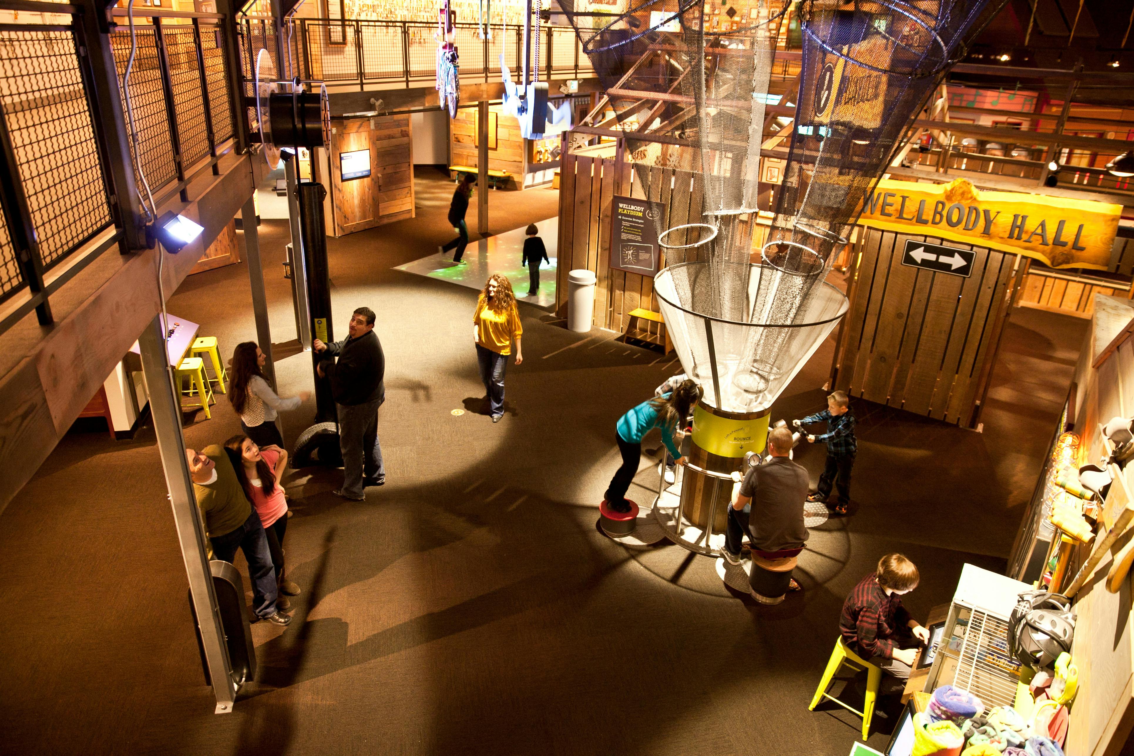 探索互动科学中心展览的人们，这里有各种仪器、照明和信息展示。