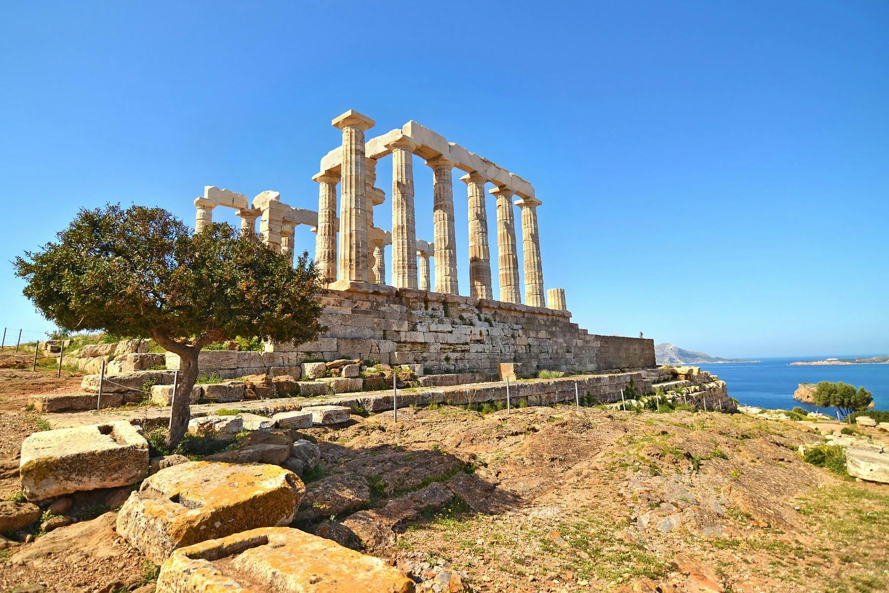 希腊苏尼翁角（ Cape Sounio ）蓝天下的波塞冬神庙（ Temple of Poseidon ）古代大理石柱升起在爱琴海上方的岩石山顶上。