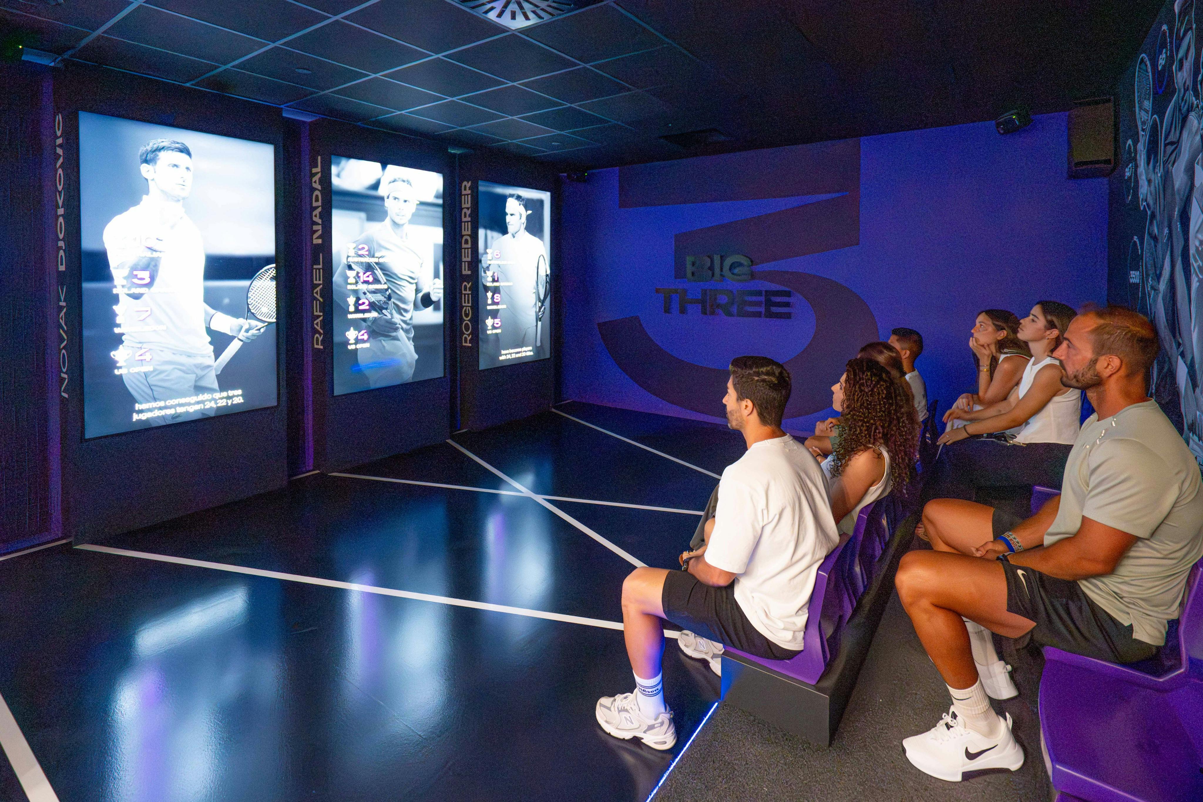 A person sitting in a room with illuminated panels displaying images and names of tennis players. The room is labeled 'Big Three.'