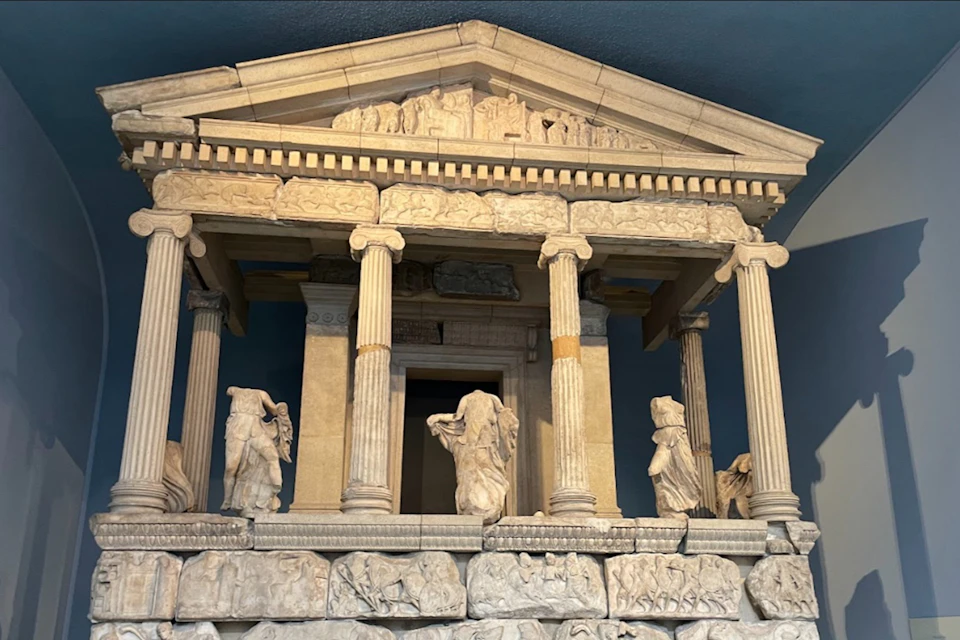 A detailed model or reconstruction of an ancient Greek-style temple with columns and sculptural decorations.