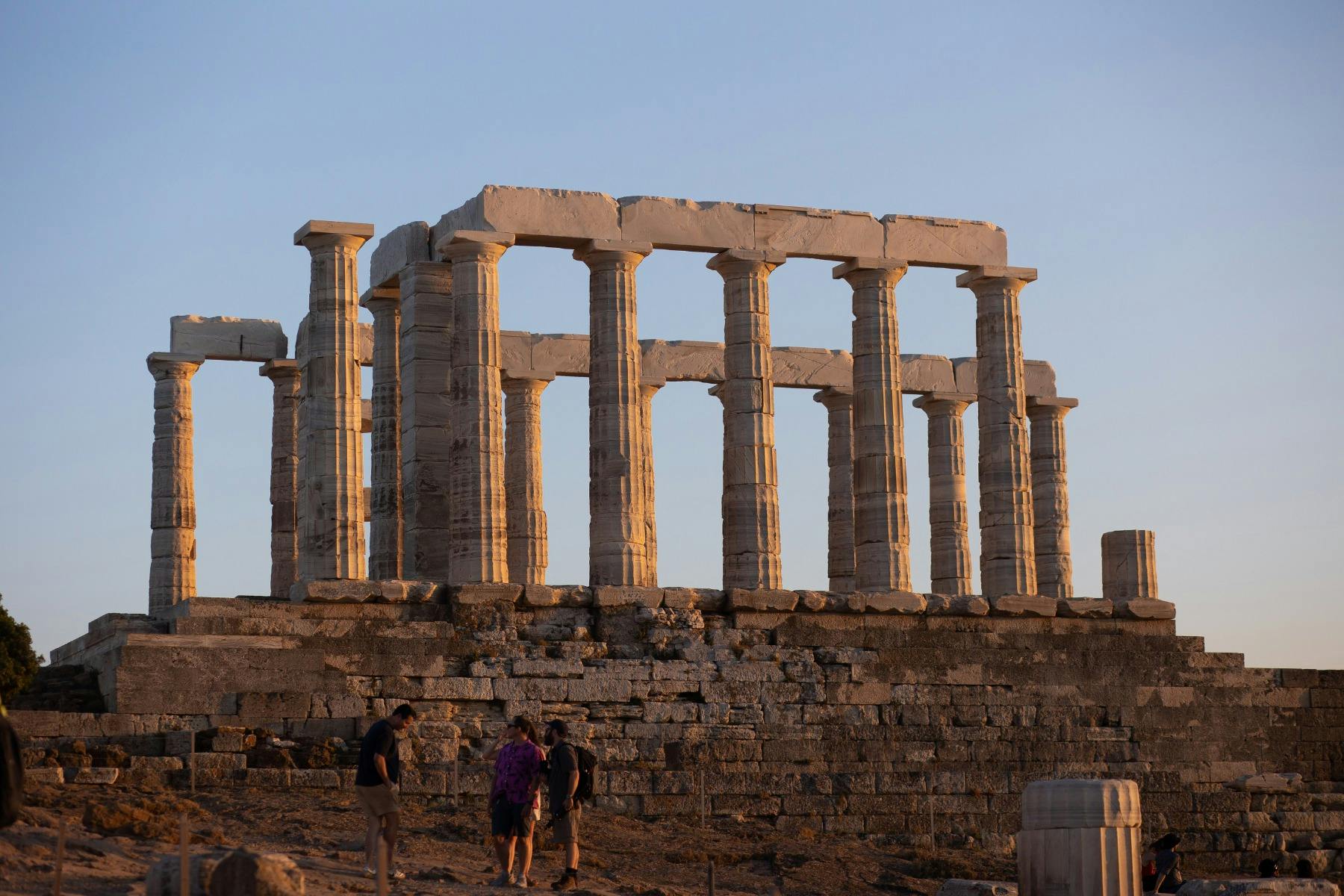 The Temple of Poseidon in Cape Sounion glowing in warm sunset light, highlighting its ancient marble columns