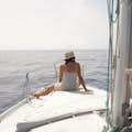Chica sentada en el barco observando el mar
