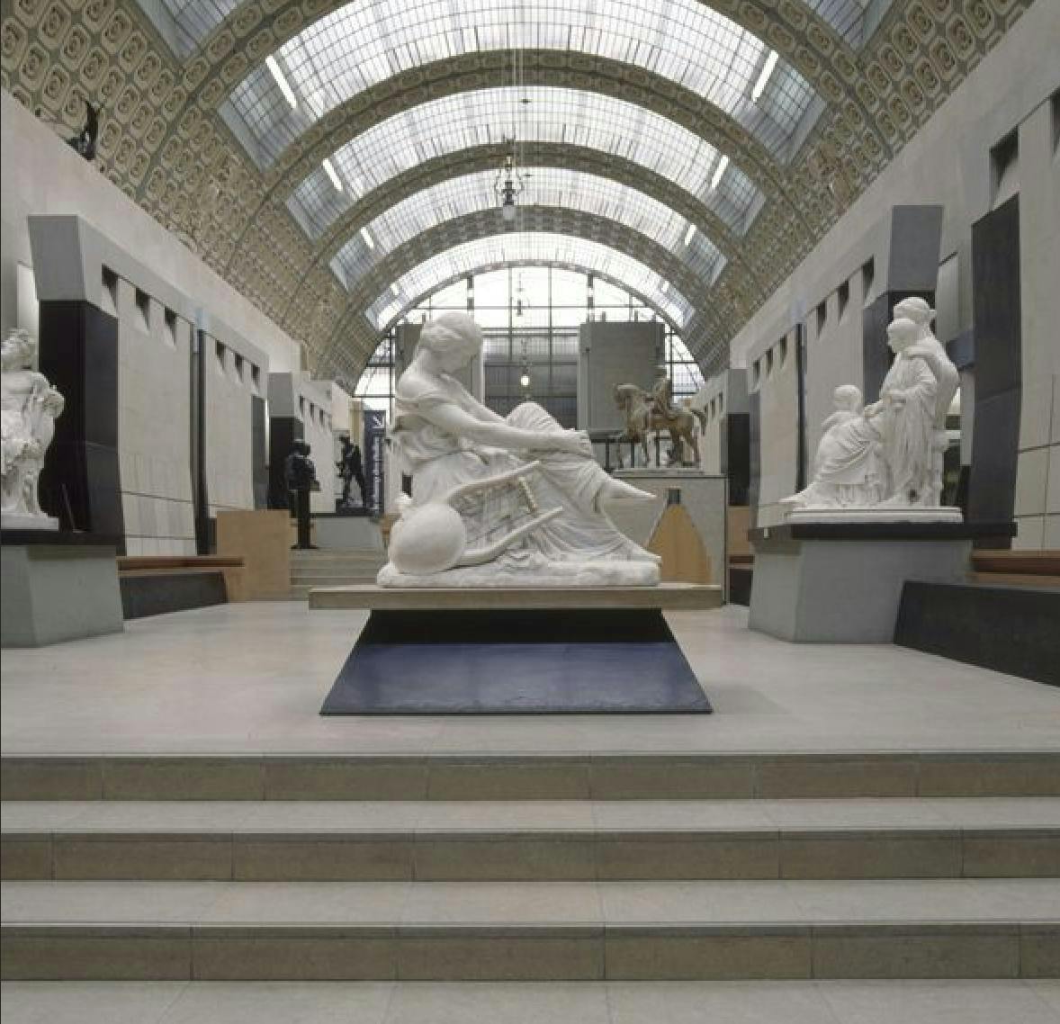 외관에 노출된 구조 요소와 유리로 둘러싸인 에스컬레이터가 있는 건물 외관으로 강철 프레임워크가 드러납니다.