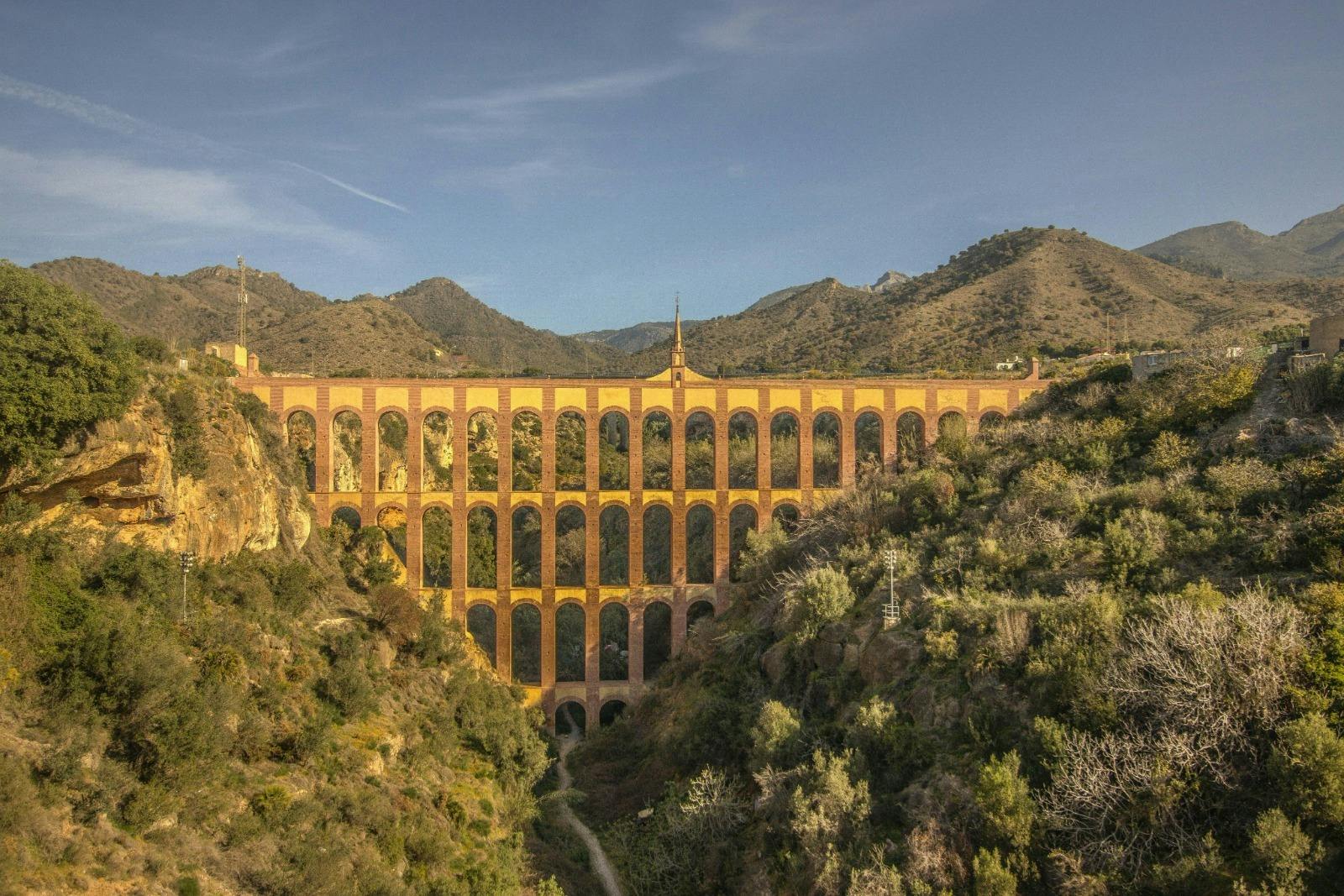 Águila Aqueduct, Nerja  
Impressive 19th-century aqueduct, nestled between mountains, with a brick structure and arches.