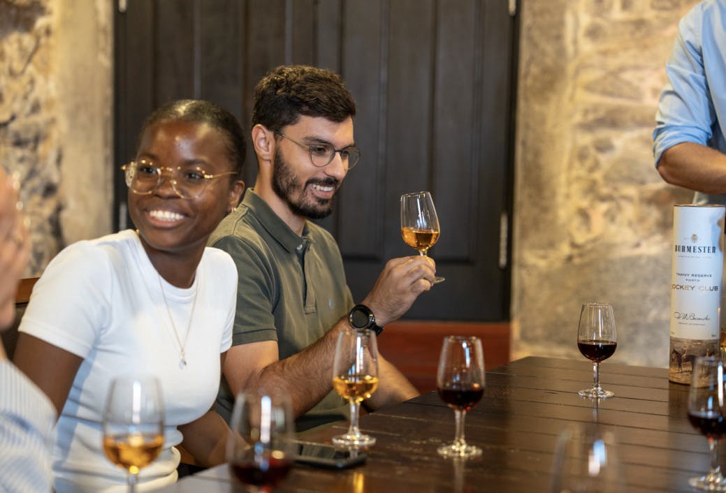 テーブルに座り、笑顔でワイングラスを持っている2人。