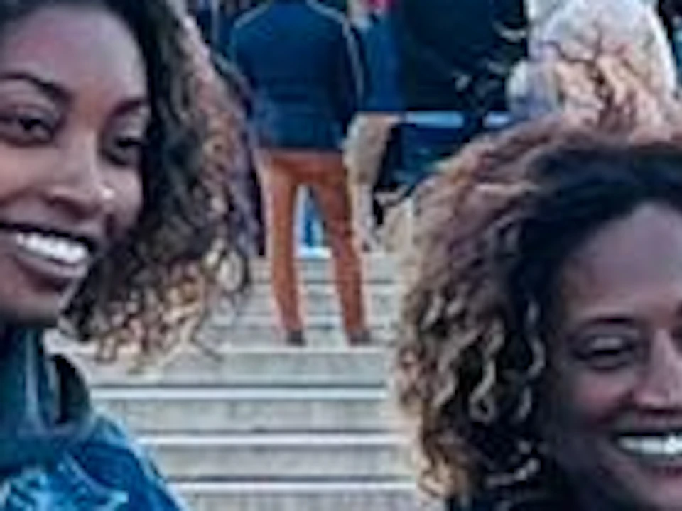 Two people standing with bicycles in front of the Lincoln Memorial, with other visitors on the steps.