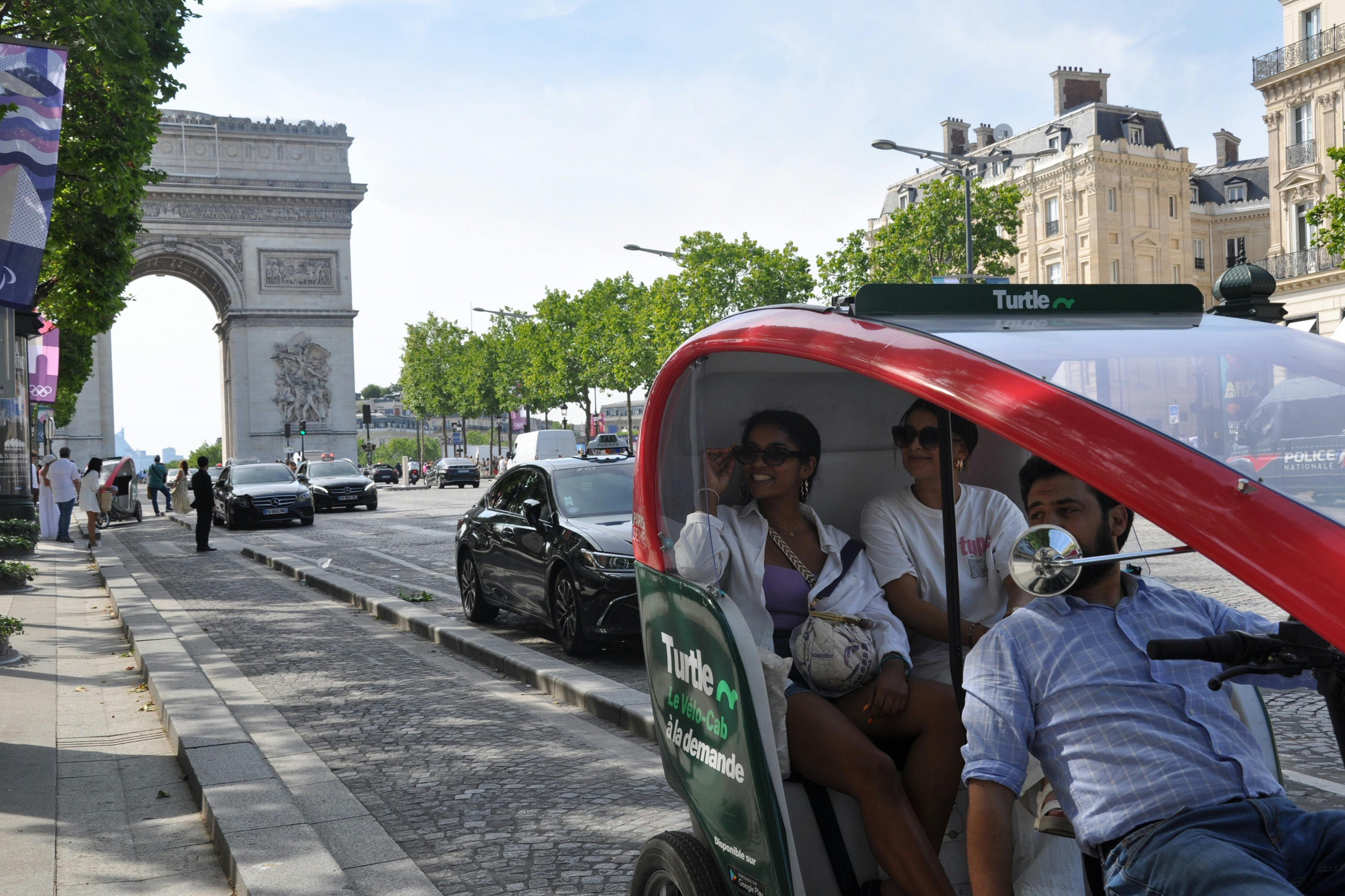 三个人坐在城市街道上的一辆绿白相间的人力车上，背景中可以看到汽车和建筑物。