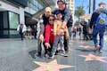 A  Hollywood Walk of Fame area  Tourist is happy with their own replica star personalized for a photo.#family