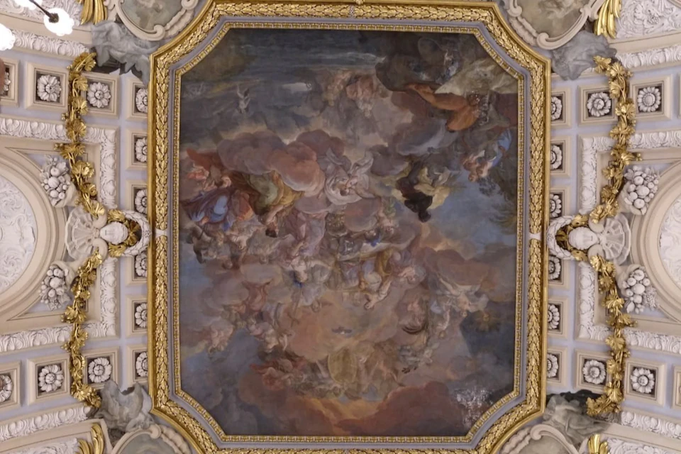 A detailed ceiling fresco depicting a dramatic scene with clouds, figures, and ornate gold framing in a classical style.