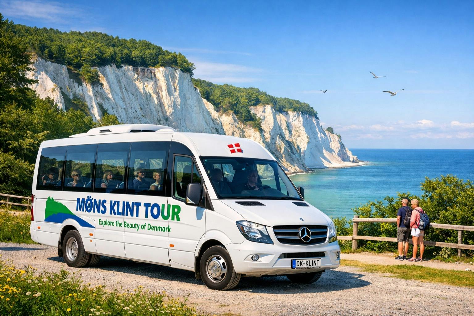 "Møns Klint Tour" 브랜딩이 있는 흰색 투어 밴이 하얀 절벽과 맑은 하늘 아래 바다의 경치 근처에 주차되어 있습니다.