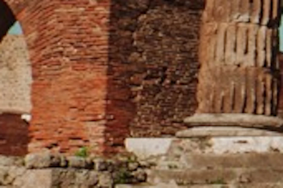 A group of people, some with backpacks, stand near ancient ruins under a clear sky. One person holds a white umbrella marked 'Askos.'