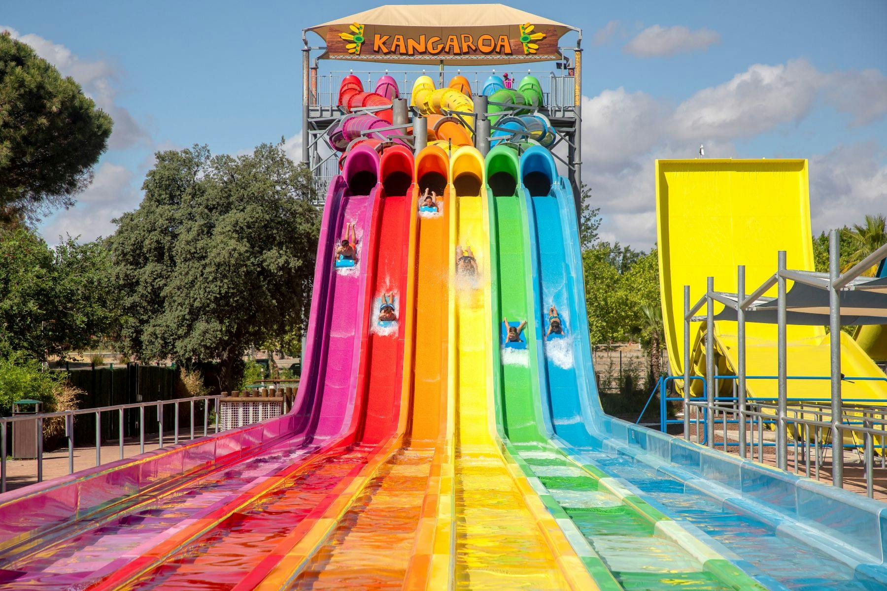 Una atracció de tobogans d'un parc aquàtic amb sis tobogans de colors i corredors que es llisquen sota un cartell que diu "Kangarooa".