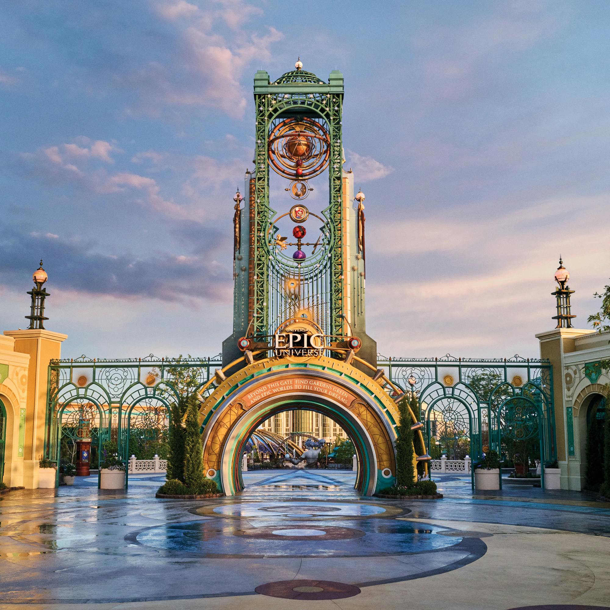 Decorative arched entrance to a theme park with intricate designs, a large clock, and a sign reading "Epic" at sunset.