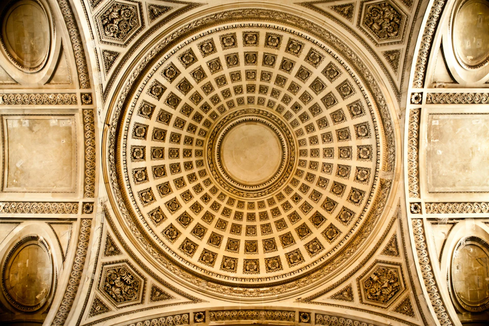 Ornate domed ceiling with intricate square and circular patterns, bordered by detailed architectural designs.