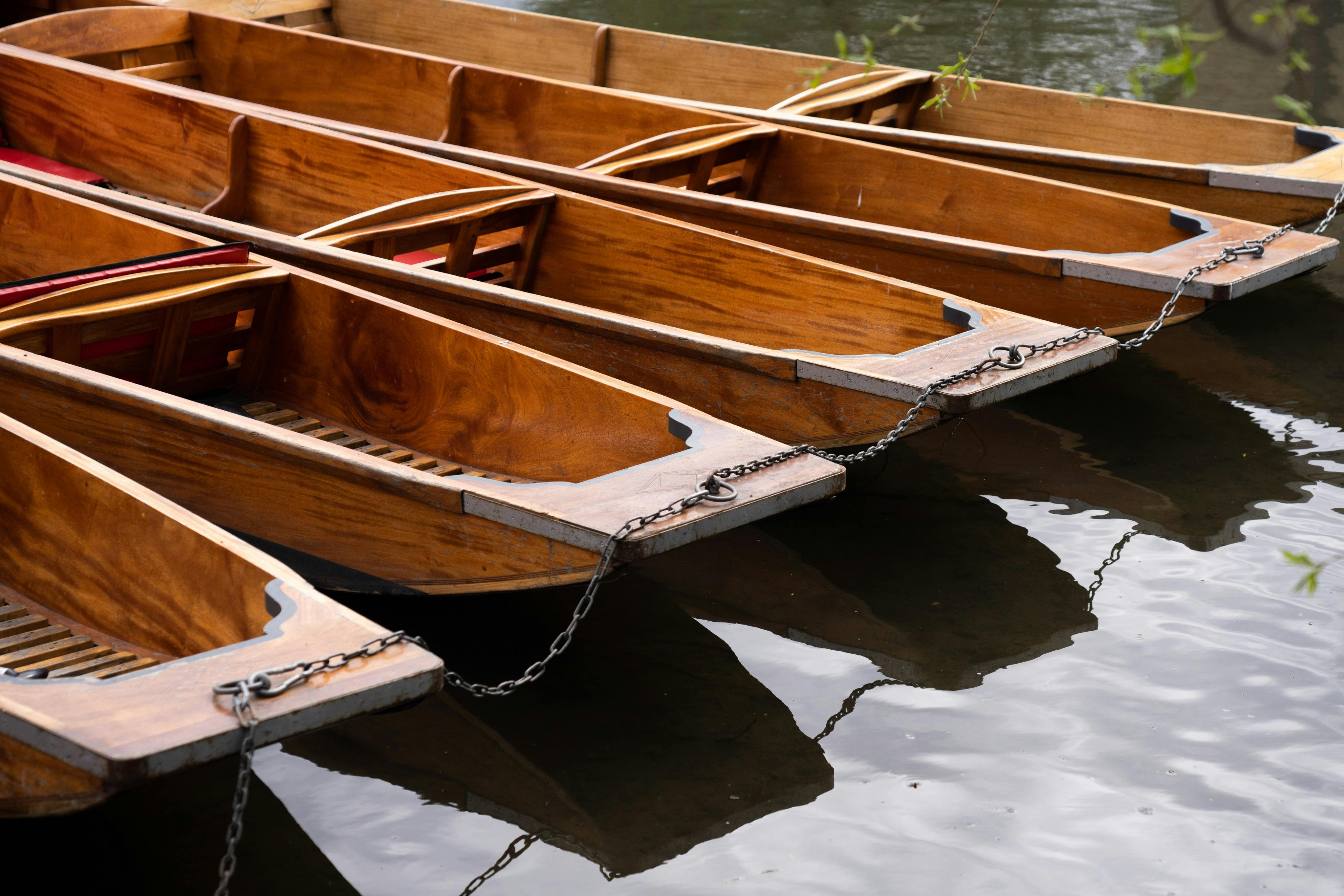 Mit Ketten zusammengebundene Holzboote, die auf dem ruhigen Wasser treiben.