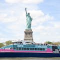 Статуя Свободы за туристической лодкой Большого города