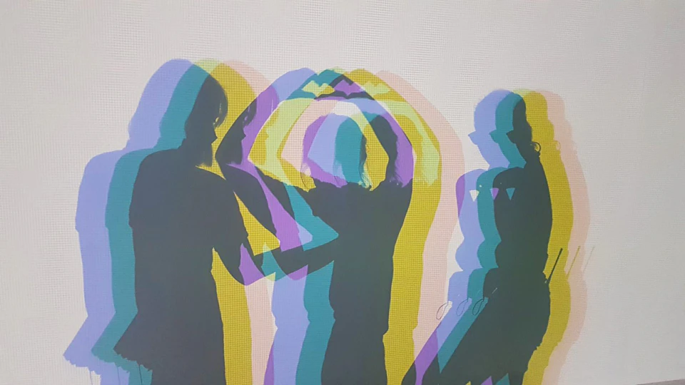 Silhouettes of people with overlapping colorful shadows on a white background.