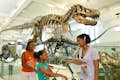 famiglia da uno scheletro di dinossauro al Museo Americano di Storia Naturale di New York City