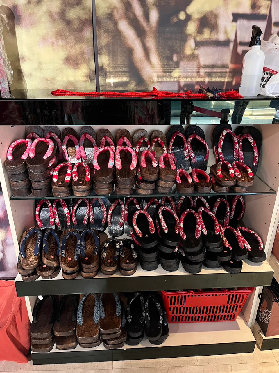 Shelves displaying rows of traditional wooden sandals with colorful straps, arranged neatly by design and size.