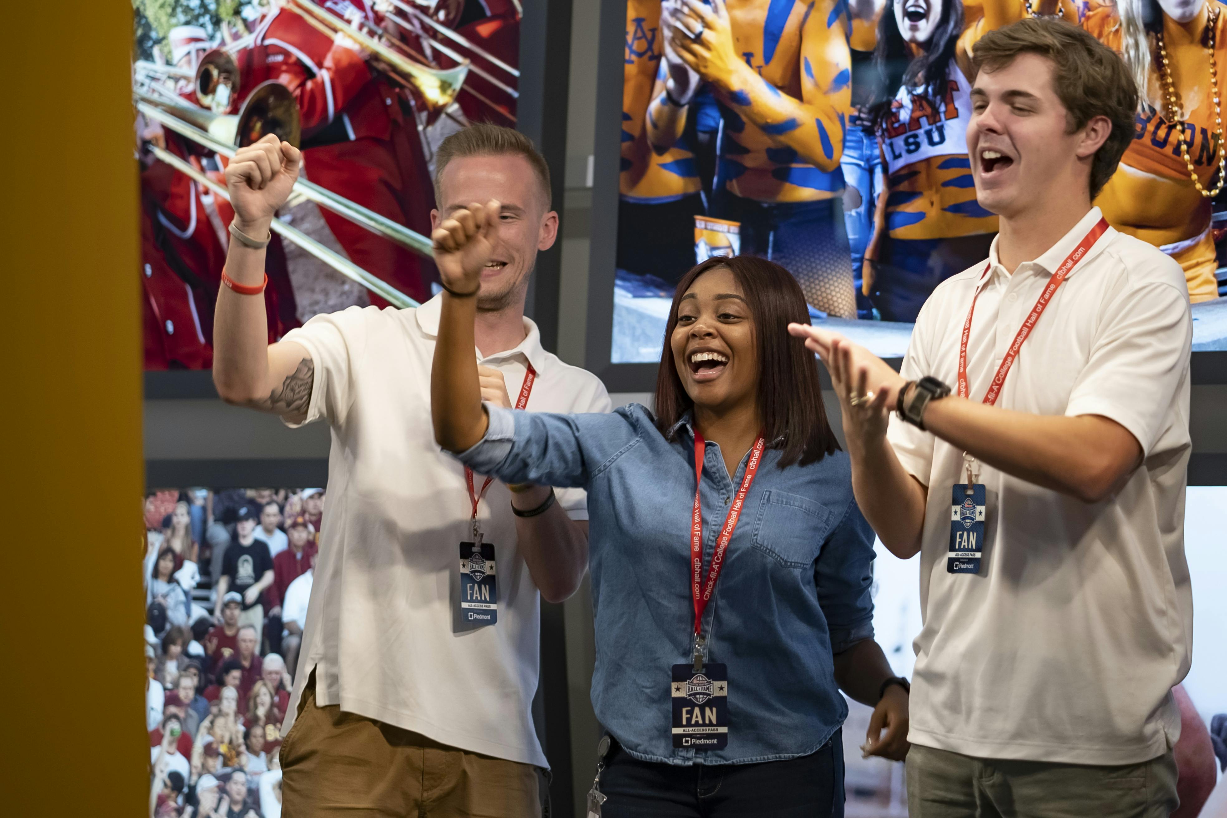 Tři lidé s „VĚJÍŘOVITÝMI“ šňůrkami jásají před sportovně laděným pozadím. Vypadají nadšeně a šťastně.