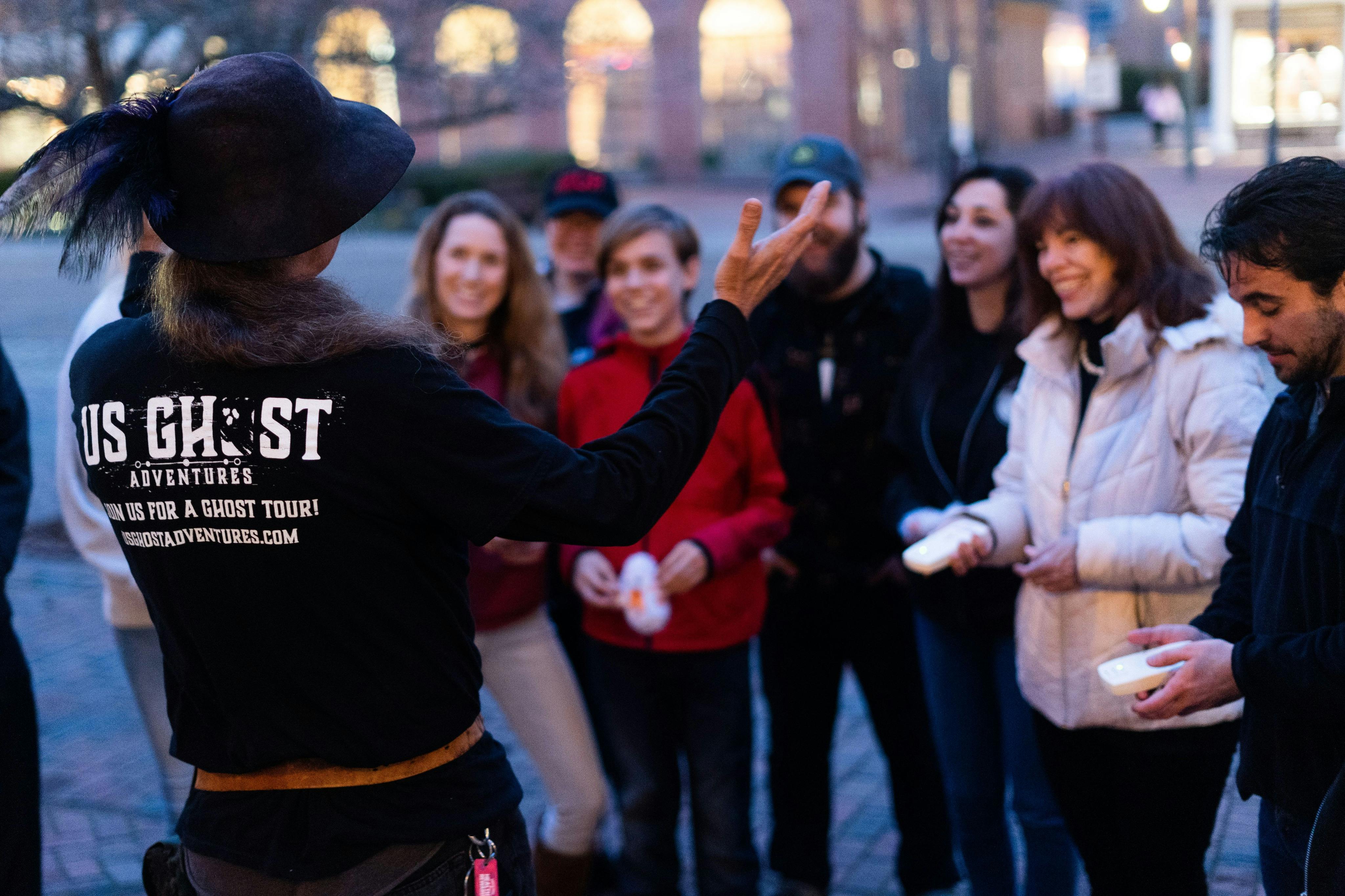 Tour guide entertaining guests as they hold EMF detectors used to pick up on ghost activity