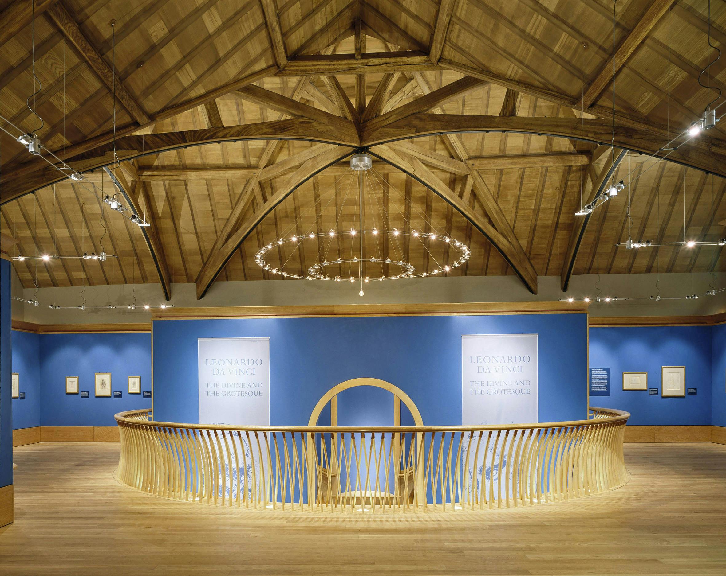 博物馆展览采用蓝色墙壁、木制栏杆和拱形天花板下的吊灯。 牌子上写着“达芬奇”。