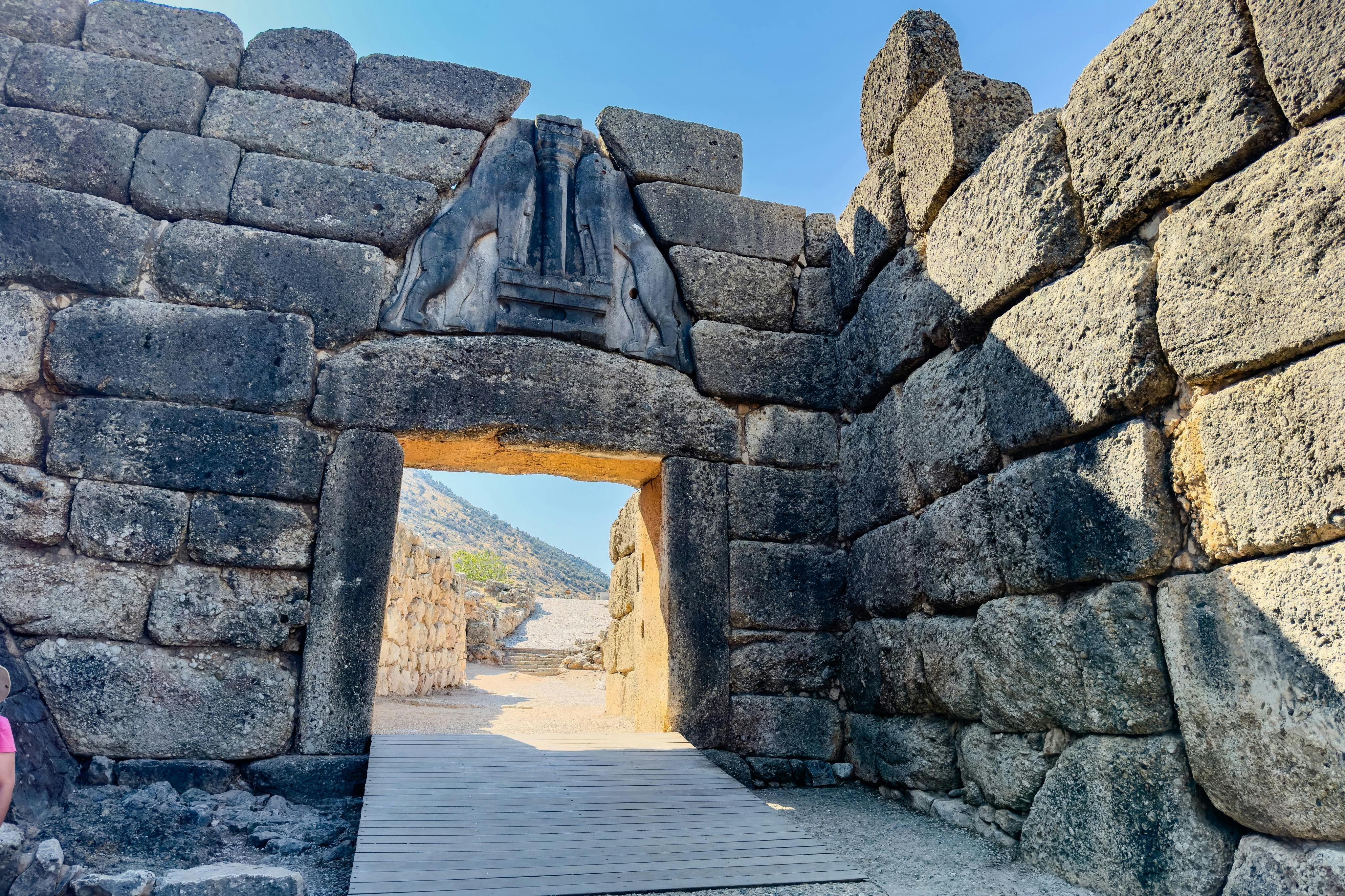 맑고 푸른 하늘 아래 커다란 암벽으로 둘러싸인 고대 부조 조각이 있는 석문.