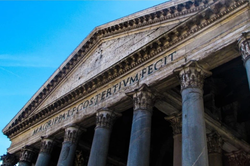 The image shows the front pediment and columns of the Pantheon in Rome, with Latin inscription visible on the frieze.