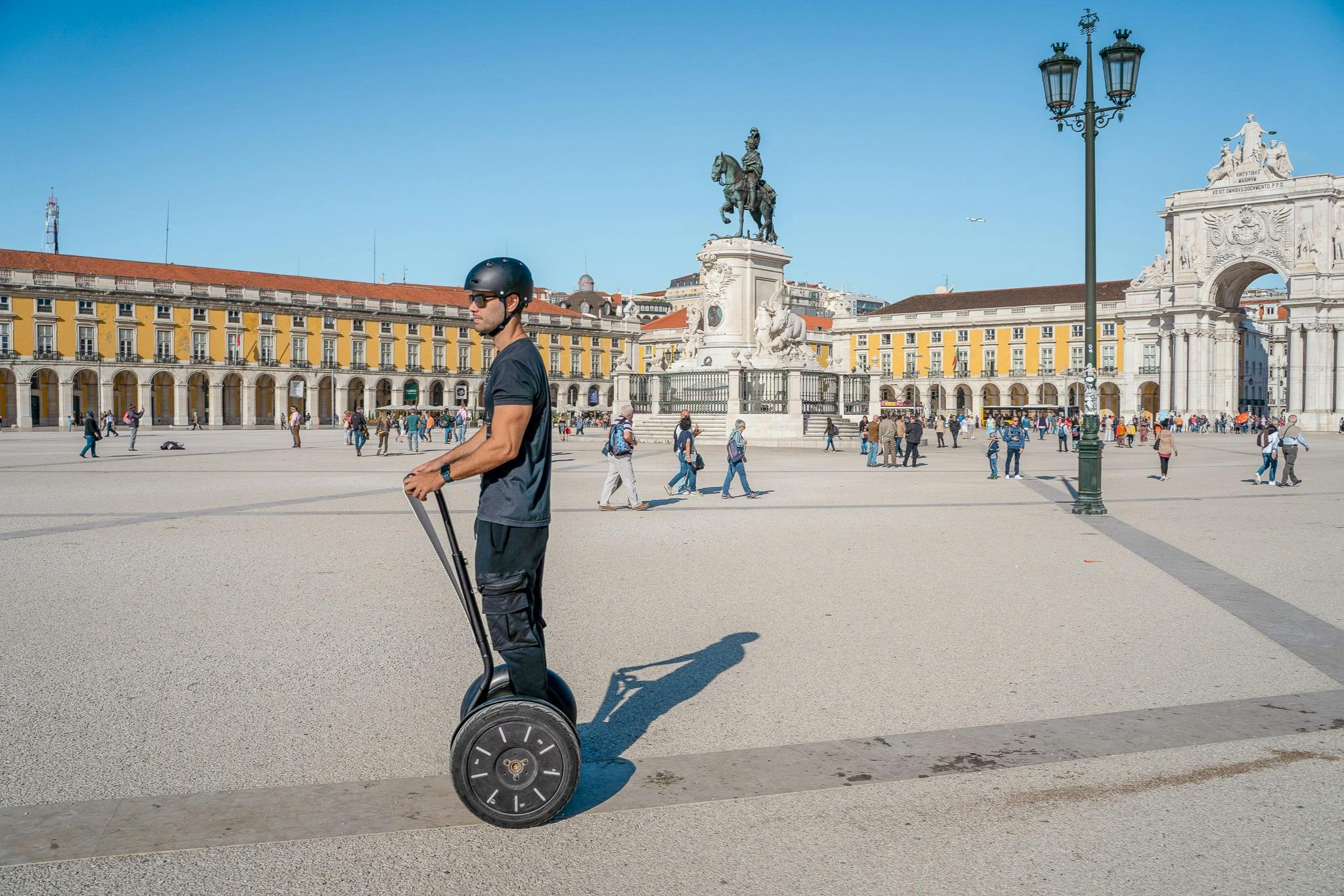 Tourists exploring Lisbon with a Segway guide tour. On Commerce Square.