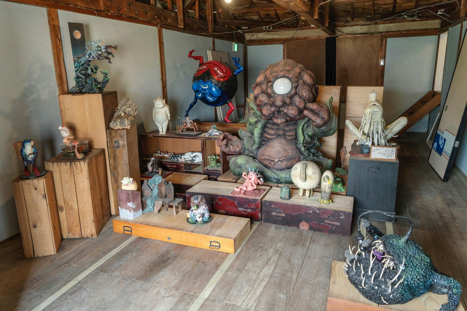 A room filled with various sculptures and art pieces, including a large organic figure and other unique creations.