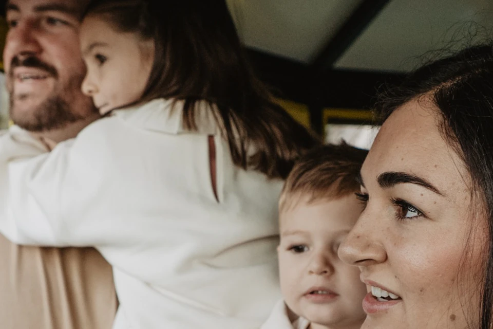 A family of four in a yellow cable car, looking out the windows and enjoying the view of the landscape outside.