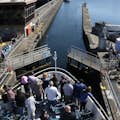 Menschen am Bug eines Argosy-Boots beobachten, wie sich das Tor der Schleusenkammer ins Süßwasser öffnet