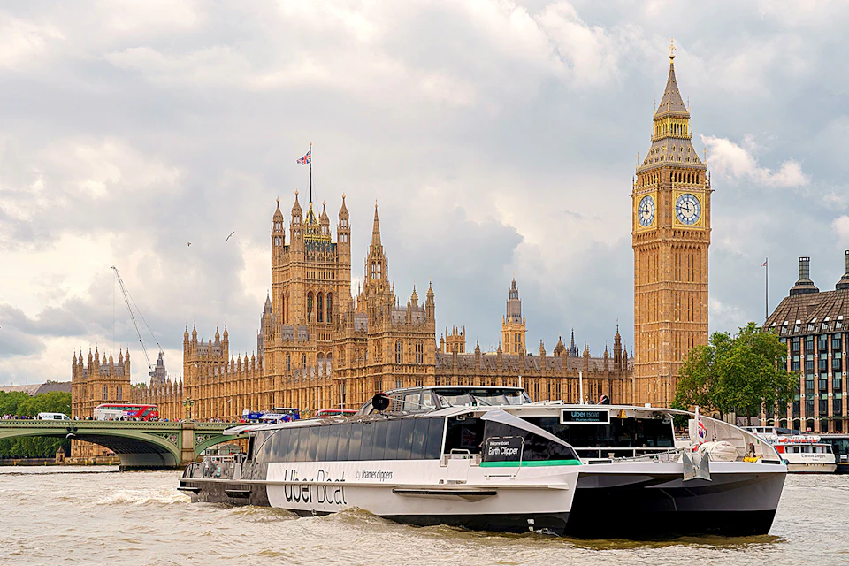 A riverboat labeled 'Uber Boat' on the Thames with the Palace of Westminster and Big Ben in the background.