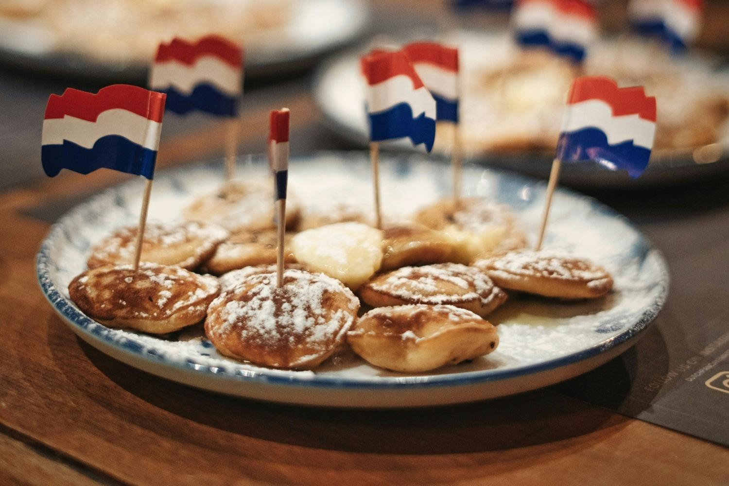 네덜란드 국기를 닮은 작은 깃발을 얹고 설탕 가루를 뿌린 작은 페이스트리 한 접시.