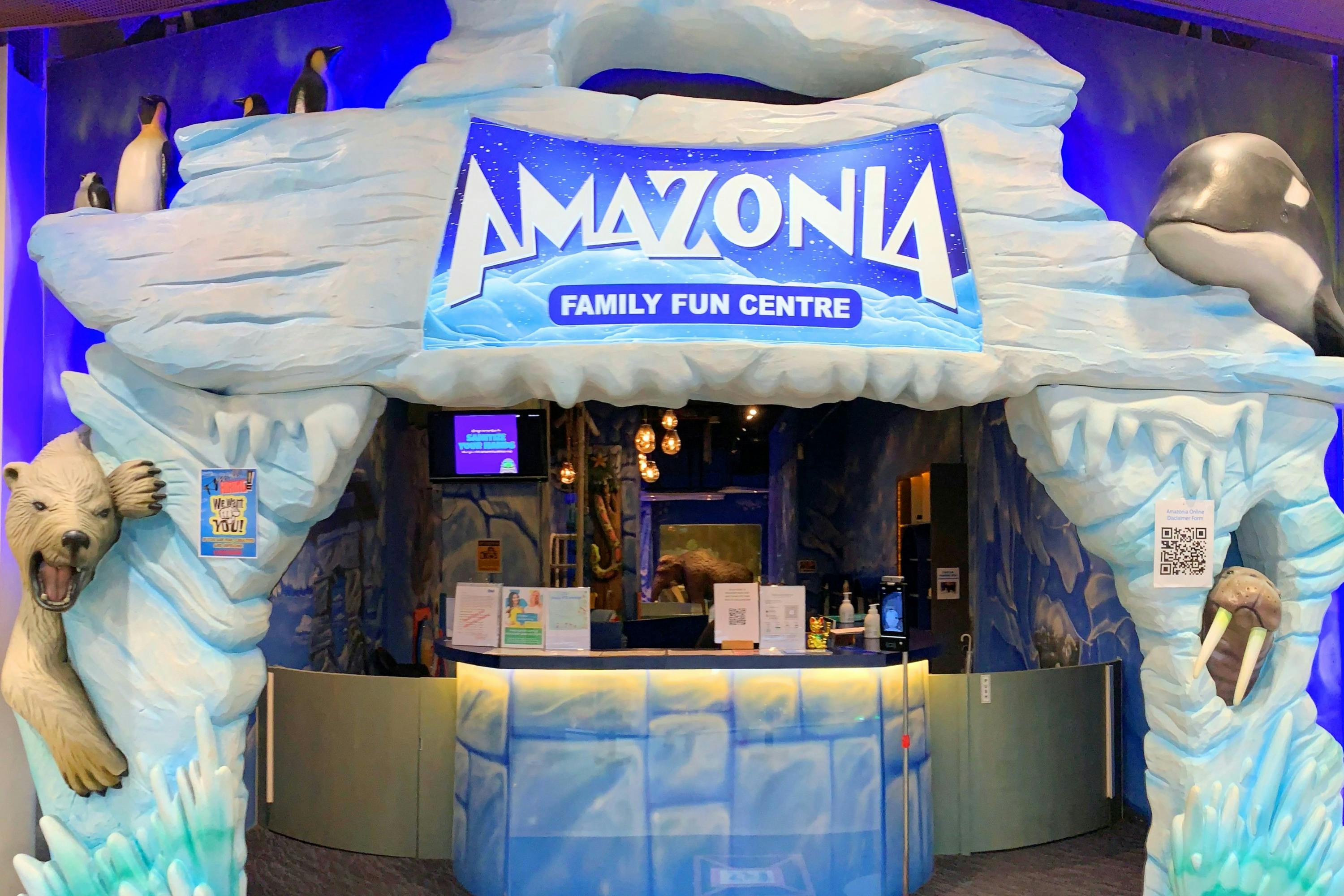 Entrance to Amazonia Family Fun Centre, featuring a cave-like icy design and a reception counter with signs and decorations.
