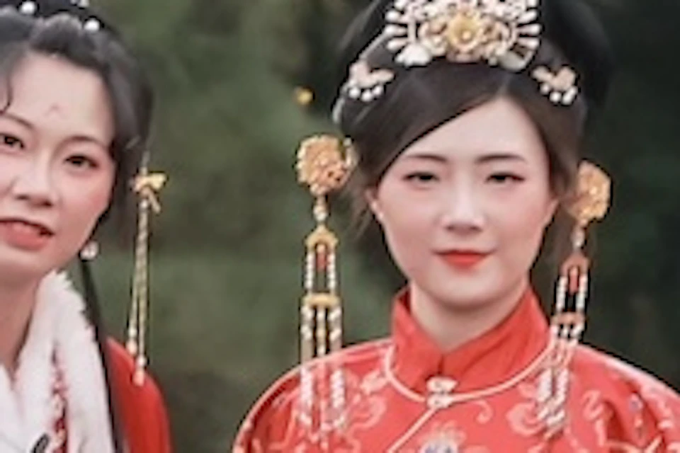 A group of people in traditional attire standing on a wooden bridge in a garden with trees and greenery in the background.