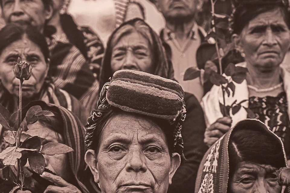 A person is looking at an exhibit featuring a large black-and-white photograph of indigenous people at the World Press Photo 2026.