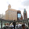 On the top-deck of a live guided open-top bus tour of Madrid