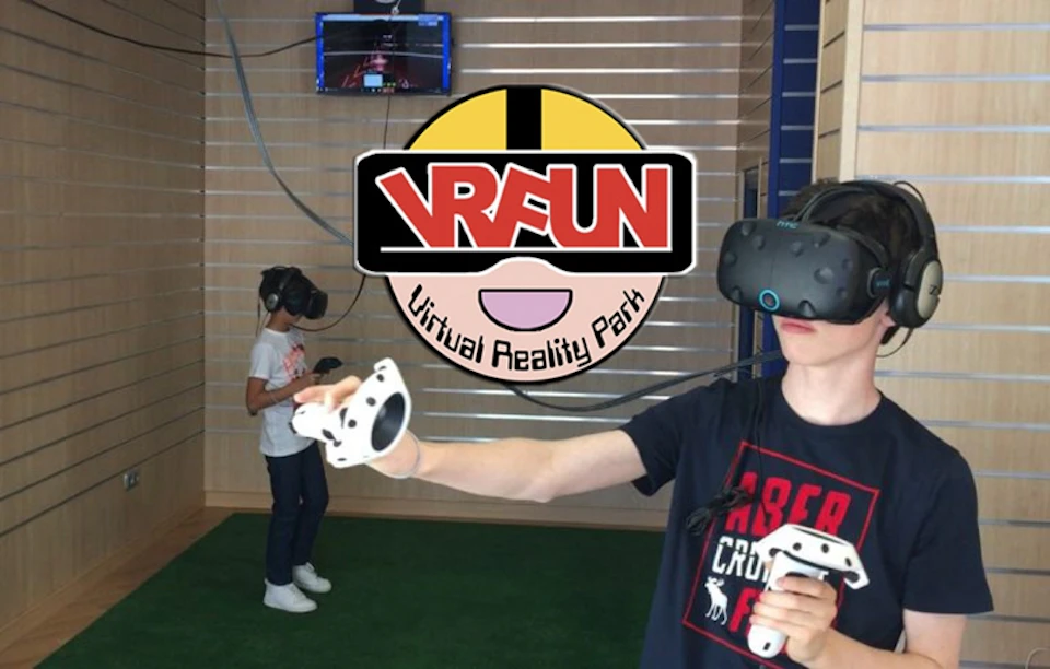 Two people wearing VR headsets and holding controllers in a virtual reality park with the logo "VRFUN Virtual Reality Park."