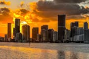 El cel daurat de la nit abraça l'horitzó de Miami i reflecteix brillantment les aigües tranquil·les.