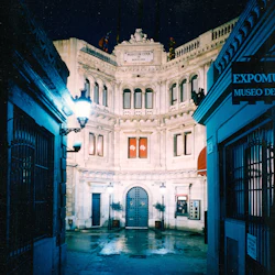 Upplyst ingång till Museo de Cera i Barcelona på natten, med utsmyckad arkitektur och smidesjärnsportar.